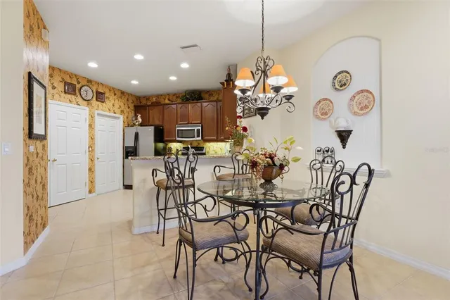 a view of a dining room and livingroom with furniture a chandelier and kitchen view