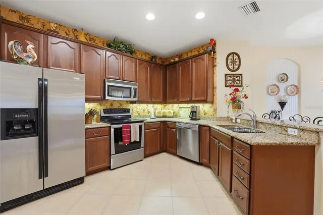 a kitchen with granite countertop stainless steel appliances and wooden cabinets