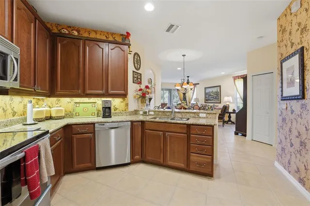 a kitchen with stainless steel appliances granite countertop a sink and dishwasher a stove top oven with wooden floor