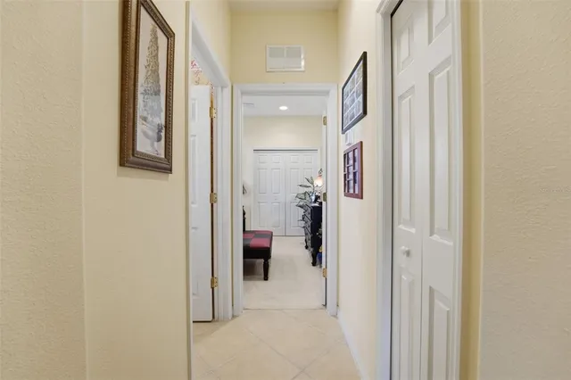 a view of a hallway with closet and mirrors