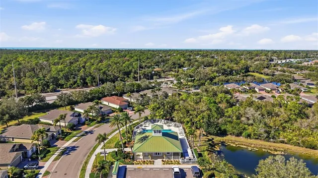 an aerial view of residential house with outdoor space and trees all around