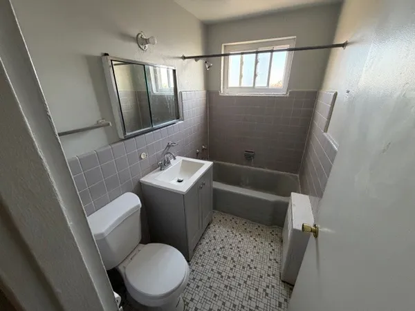 a view of an empty room with wooden floor and closet
