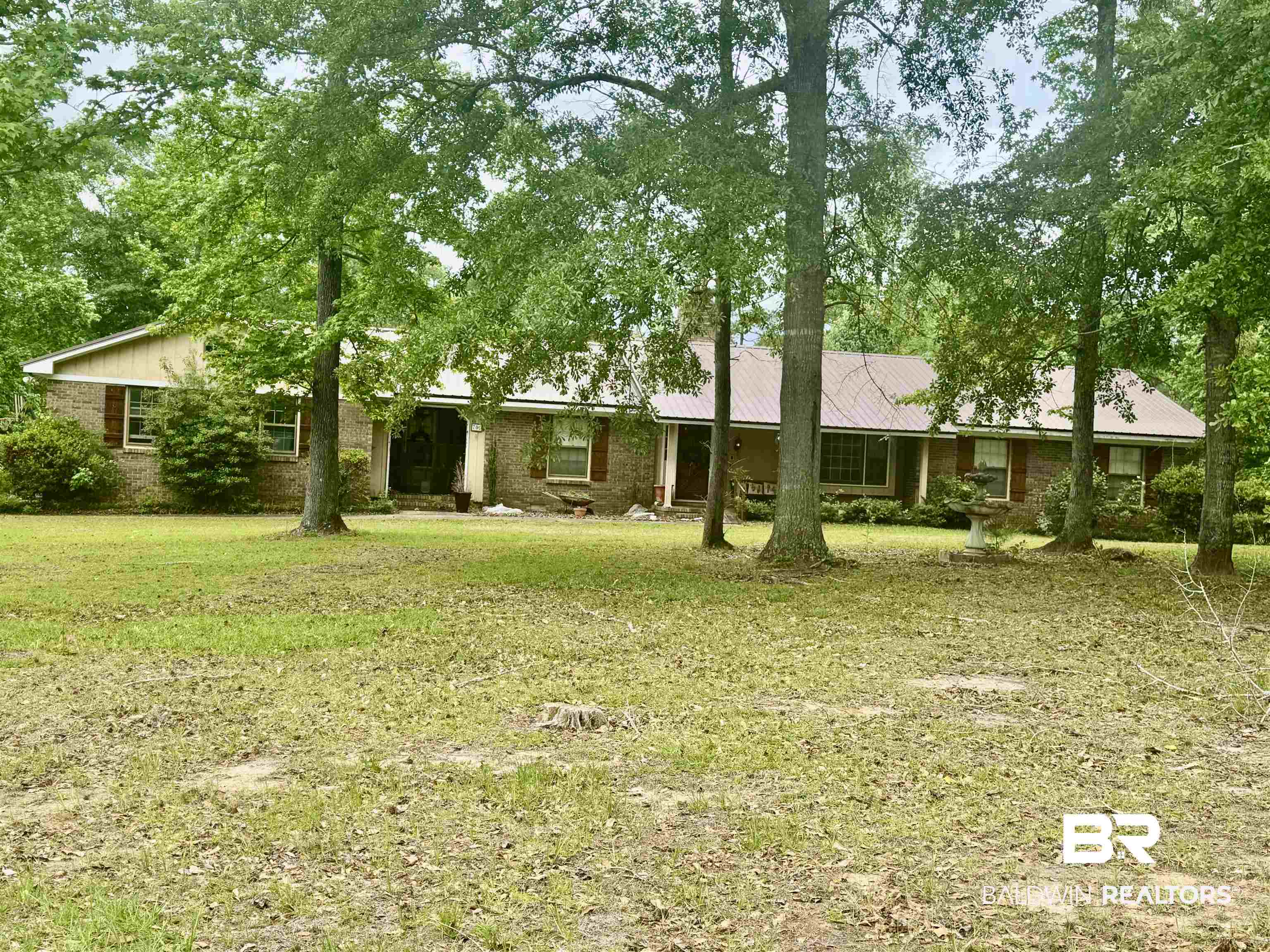 701 Forest Drive Greenville, AL 36037 - Photo 1 of 30 View of front of house with brick siding, a front yard, and metal roof