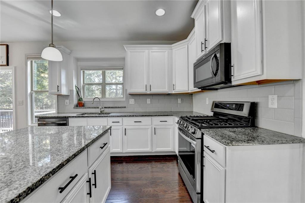 533 Widgeon Way Jefferson, GA 30549 - Photo 22 of 101 a kitchen with granite countertop cabinets stainless steel appliances a sink and a window