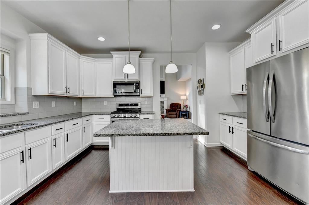 533 Widgeon Way Jefferson, GA 30549 - Photo 28 of 101 a kitchen with stainless steel appliances granite countertop a stove a sink and a refrigerator