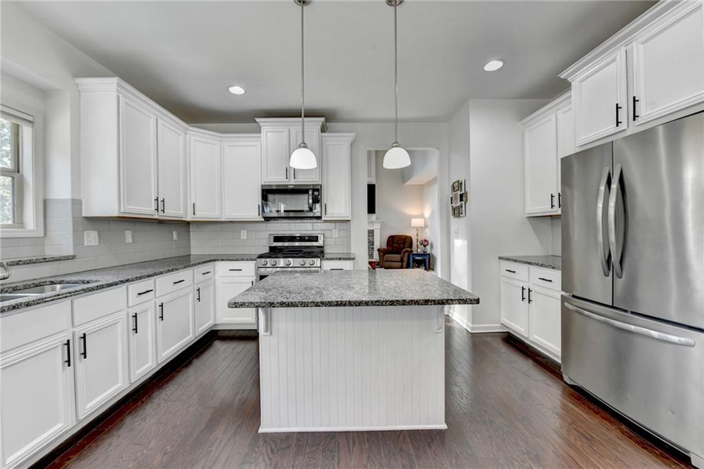 533 Widgeon Way Jefferson, GA 30549 - Photo 38 of 101 a kitchen with stainless steel appliances granite countertop a stove a sink and a refrigerator