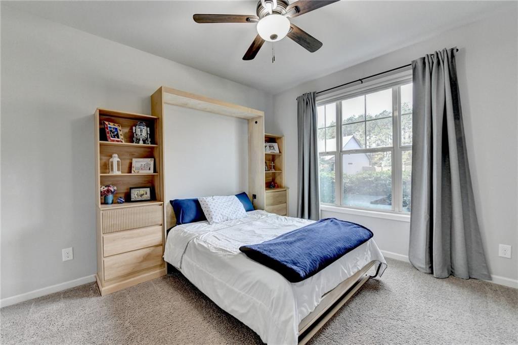 533 Widgeon Way Jefferson, GA 30549 - Photo 43 of 101 a spacious bedroom with a large bed and a chandelier fan