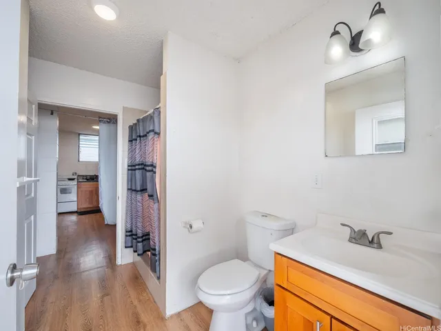 a bathroom with a granite countertop toilet sink and shower