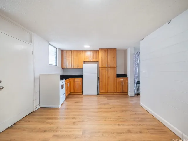 a view of a kitchen with a sink and a refrigerator