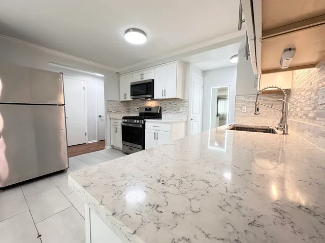 a large kitchen with cabinets and stainless steel appliances