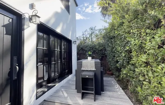 a view of a patio with couches and a table and chairs with wooden fence