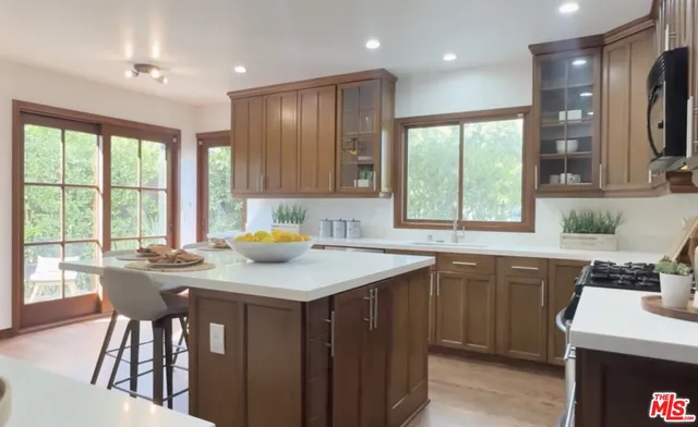 a kitchen that has a sink a table and chairs in it