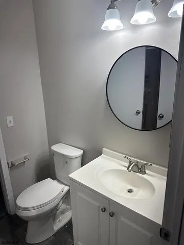 a bathroom with a toilet sink and mirror