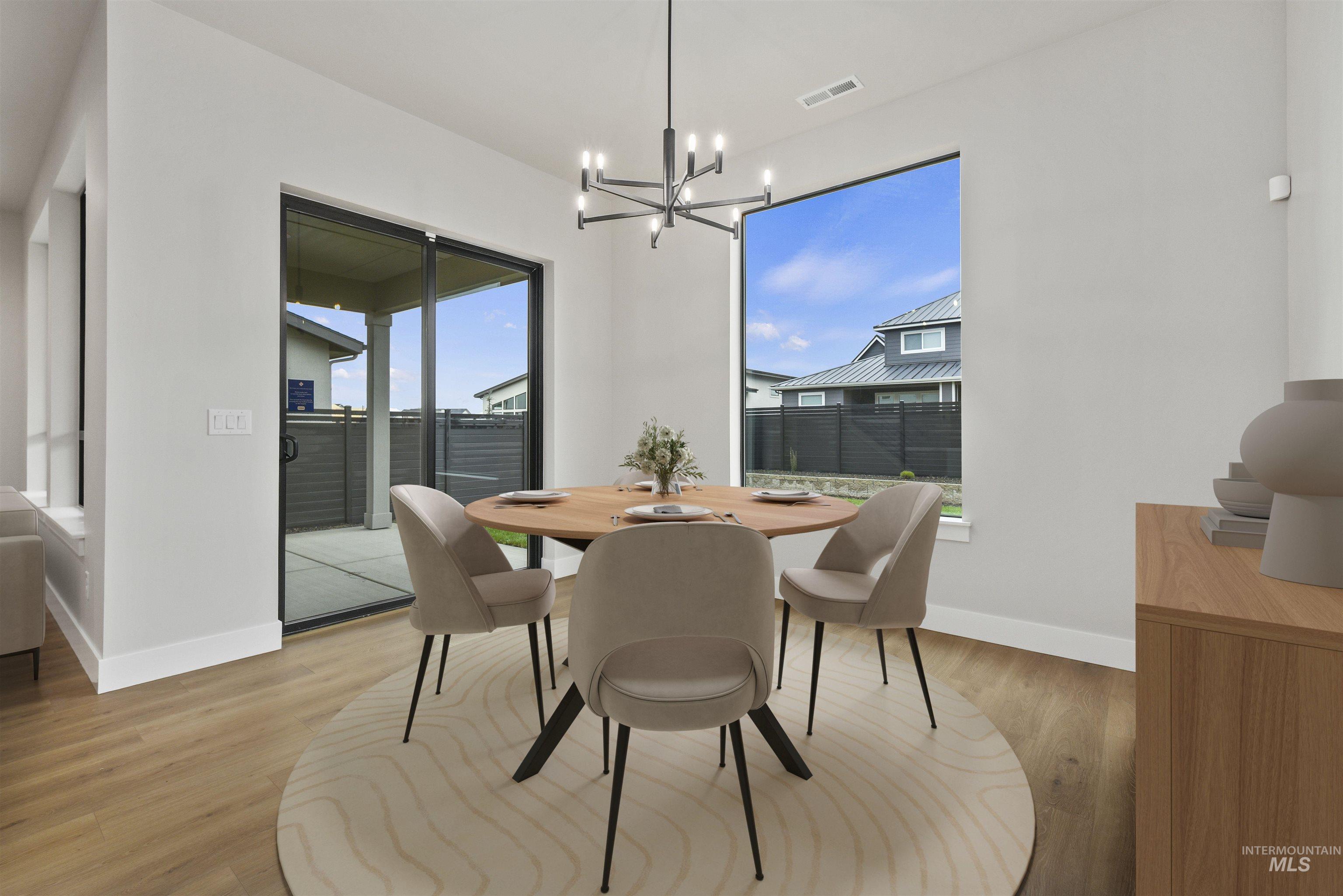 7660 West Old School Street, Unit ROUGE Meridian, ID 83646 - Photo 7 of 28 Dining area with light wood finished floors and a chandelier