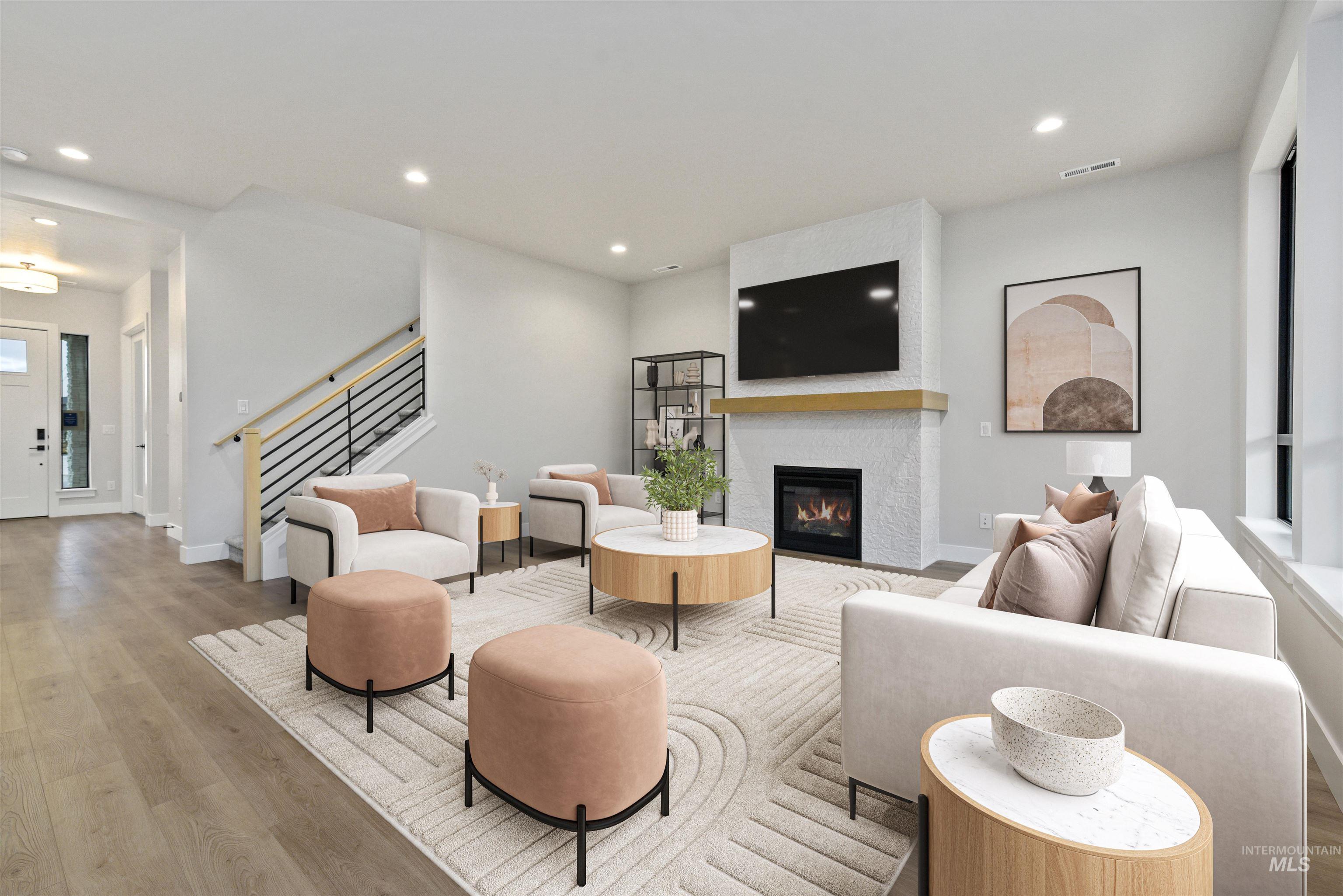 7660 West Old School Street, Unit ROUGE Meridian, ID 83646 - Photo 9 of 28 Living room featuring wood finished floors, recessed lighting, a glass covered fireplace, and stairway