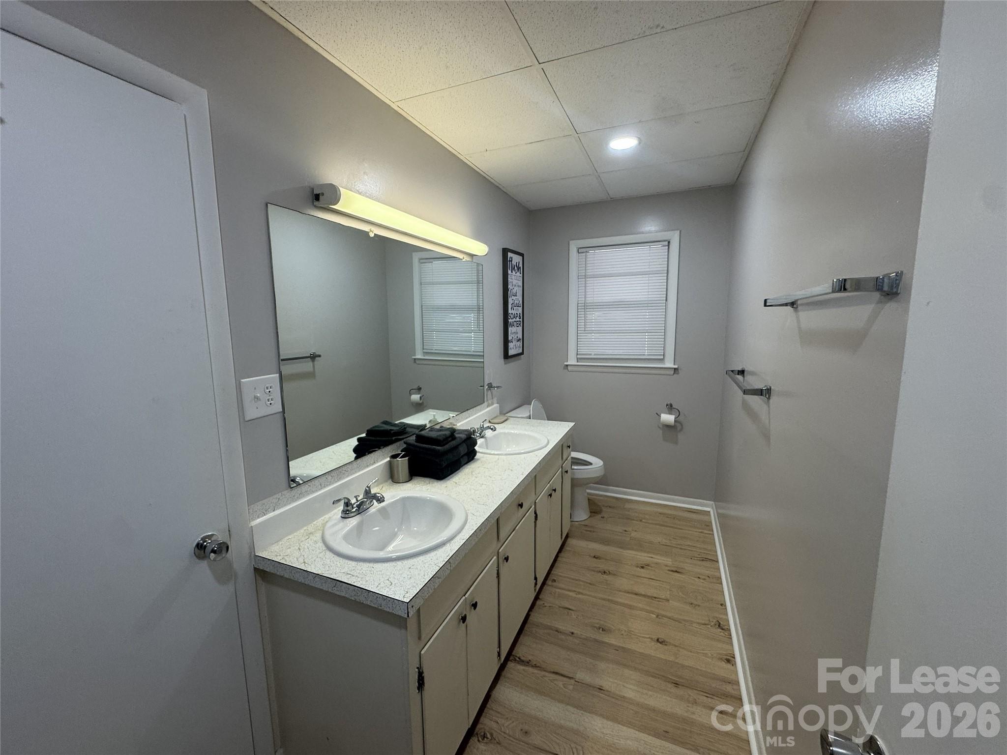 319 Connelly Springs Road, Unit A Lenoir, NC 28645 - Photo 7 of 10 a bathroom with a sink a toilet a mirror and vanity
