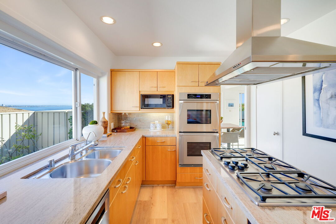 18332 Wakecrest Drive Malibu, CA 90265 - Photo 14 of 30 a kitchen with stainless steel appliances granite countertop a stove and a sink