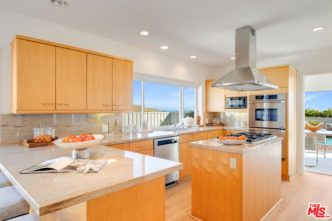 18332 Wakecrest Drive Malibu, CA 90265 - Photo 15 of 30 a kitchen with stainless steel appliances granite countertop a sink stove and cabinets