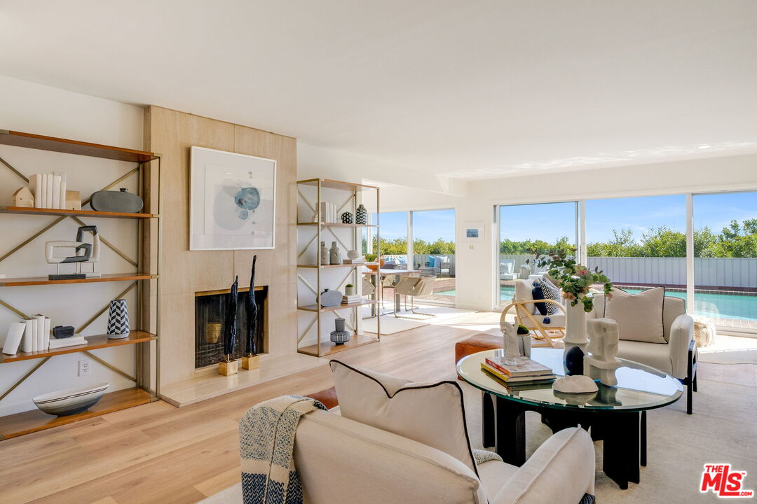18332 Wakecrest Drive Malibu, CA 90265 - Photo 5 of 30 a living room with furniture a fireplace and a floor to ceiling window