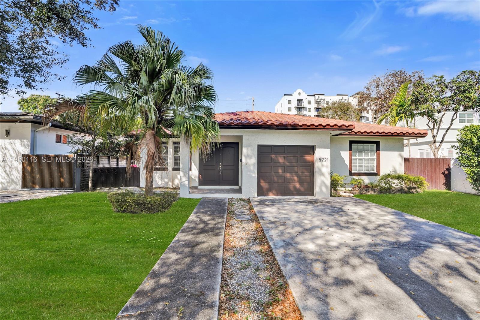 a front view of a house with a garden and yard