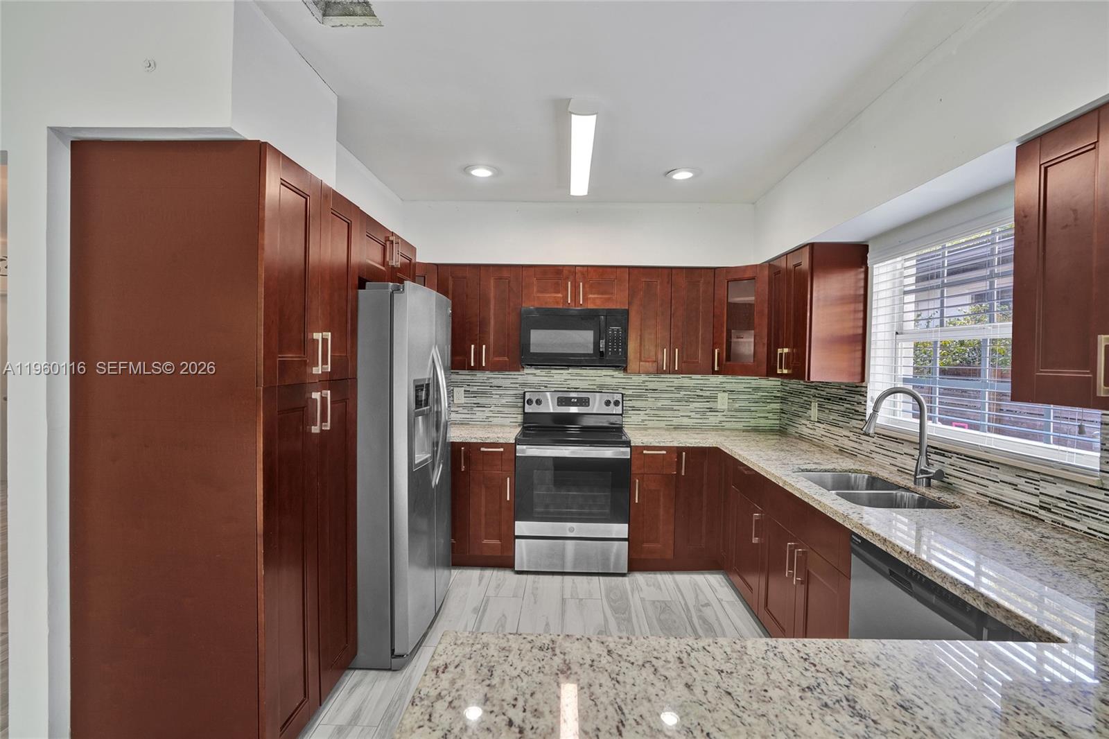 5721 Southwest 11th Street West Miami, FL 33144 - Photo 11 of 44 a kitchen with stainless steel appliances granite countertop a sink refrigerator and cabinets