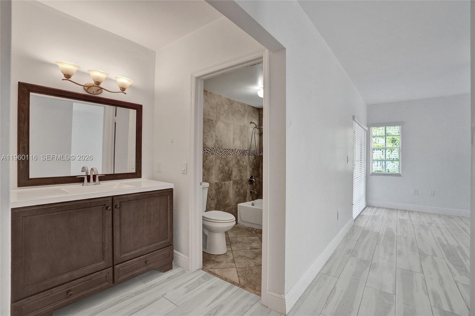 5721 Southwest 11th Street West Miami, FL 33144 - Photo 25 of 44 a bathroom with a sink a toilet and a large mirror