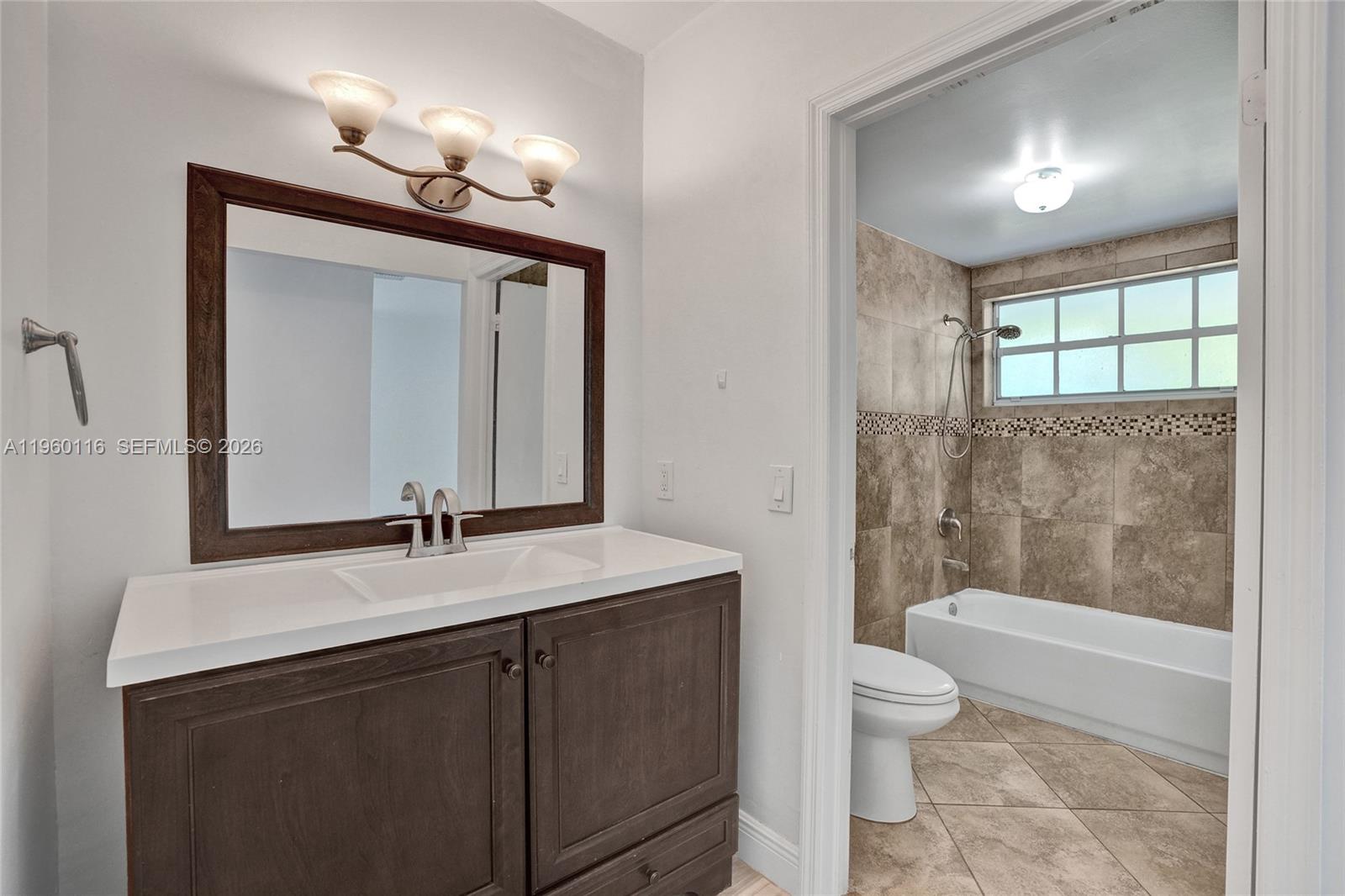 5721 Southwest 11th Street West Miami, FL 33144 - Photo 26 of 44 a bathroom with a sink a toilet a mirror a vanity and bathtub