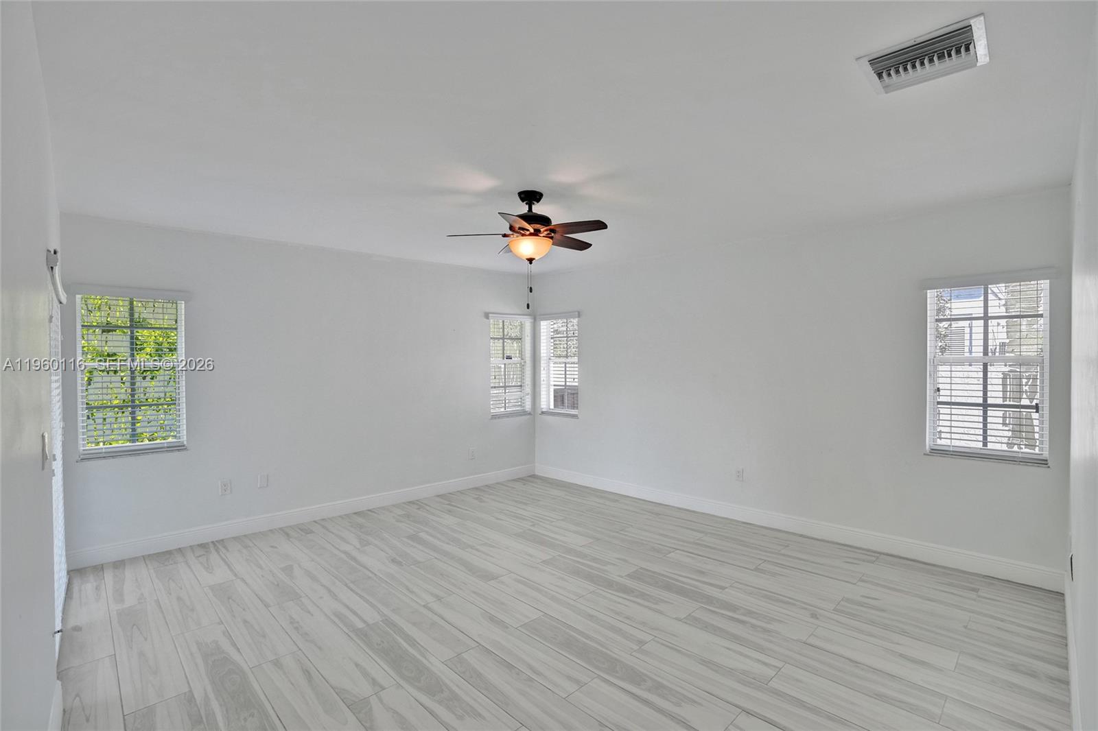 5721 Southwest 11th Street West Miami, FL 33144 - Photo 28 of 44 an empty room with wooden floor cabinet and windows
