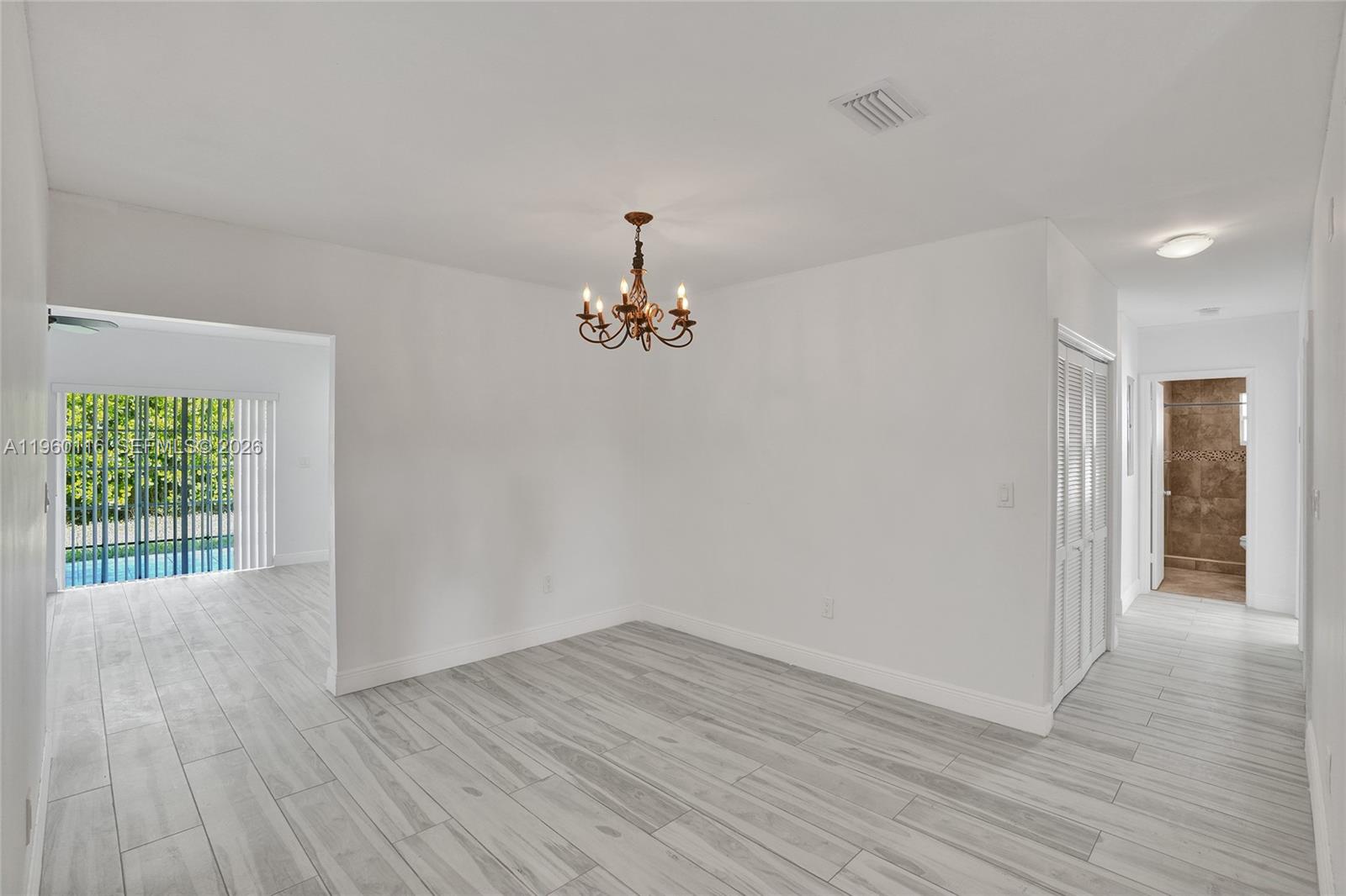 5721 Southwest 11th Street West Miami, FL 33144 - Photo 4 of 44 wooden floor in an empty room with a window