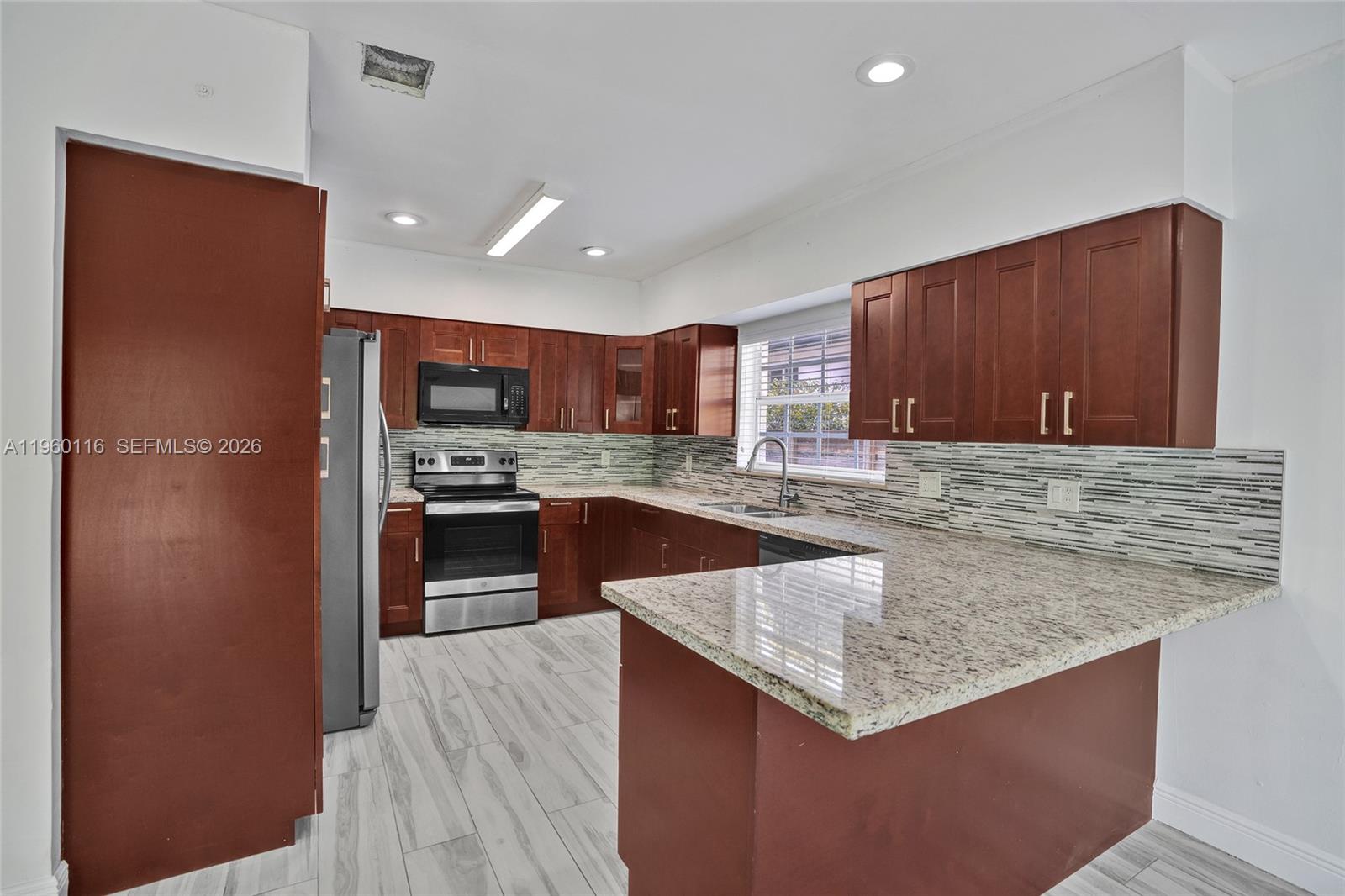 5721 Southwest 11th Street West Miami, FL 33144 - Photo 10 of 44 a kitchen with stainless steel appliances granite countertop a sink counter space and cabinets