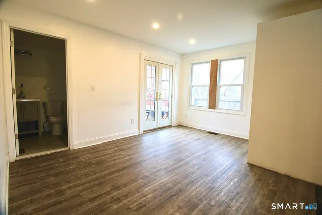 an empty room with wooden floor and windows
