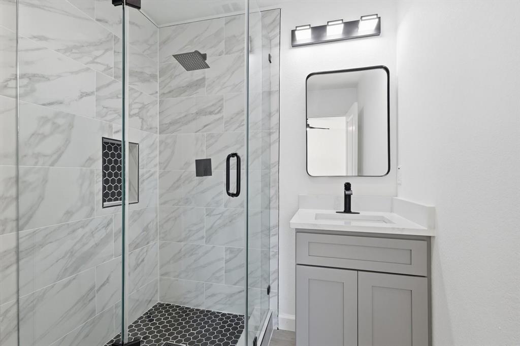 2900 Old Orchard Road Garland, TX 75041 - Photo 11 of 18 a bathroom with a sink a mirror and shower