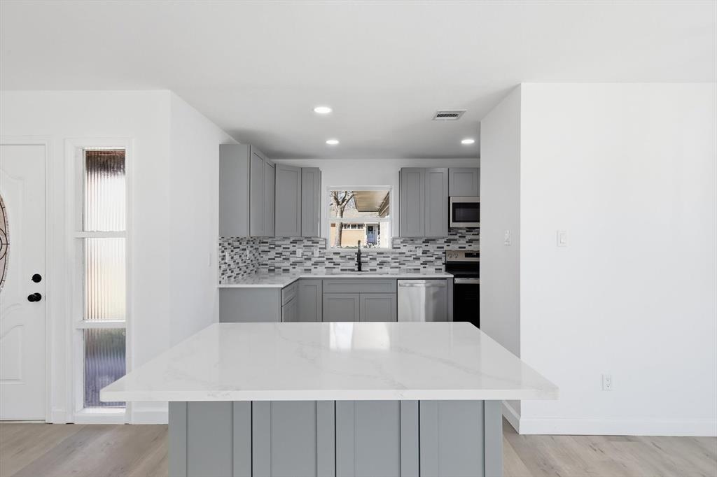 2900 Old Orchard Road Garland, TX 75041 - Photo 2 of 18 a large white kitchen with kitchen island a sink stainless steel appliances and cabinets