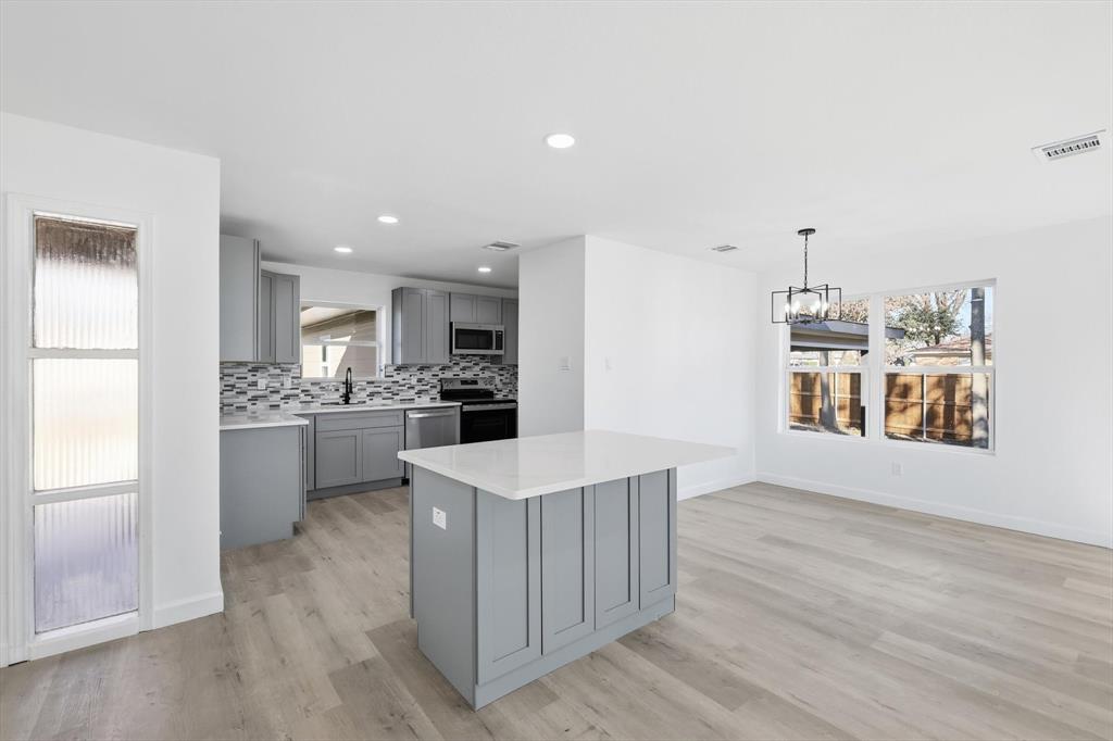 2900 Old Orchard Road Garland, TX 75041 - Photo 6 of 18 a kitchen with a sink wooden floor and white cabinets