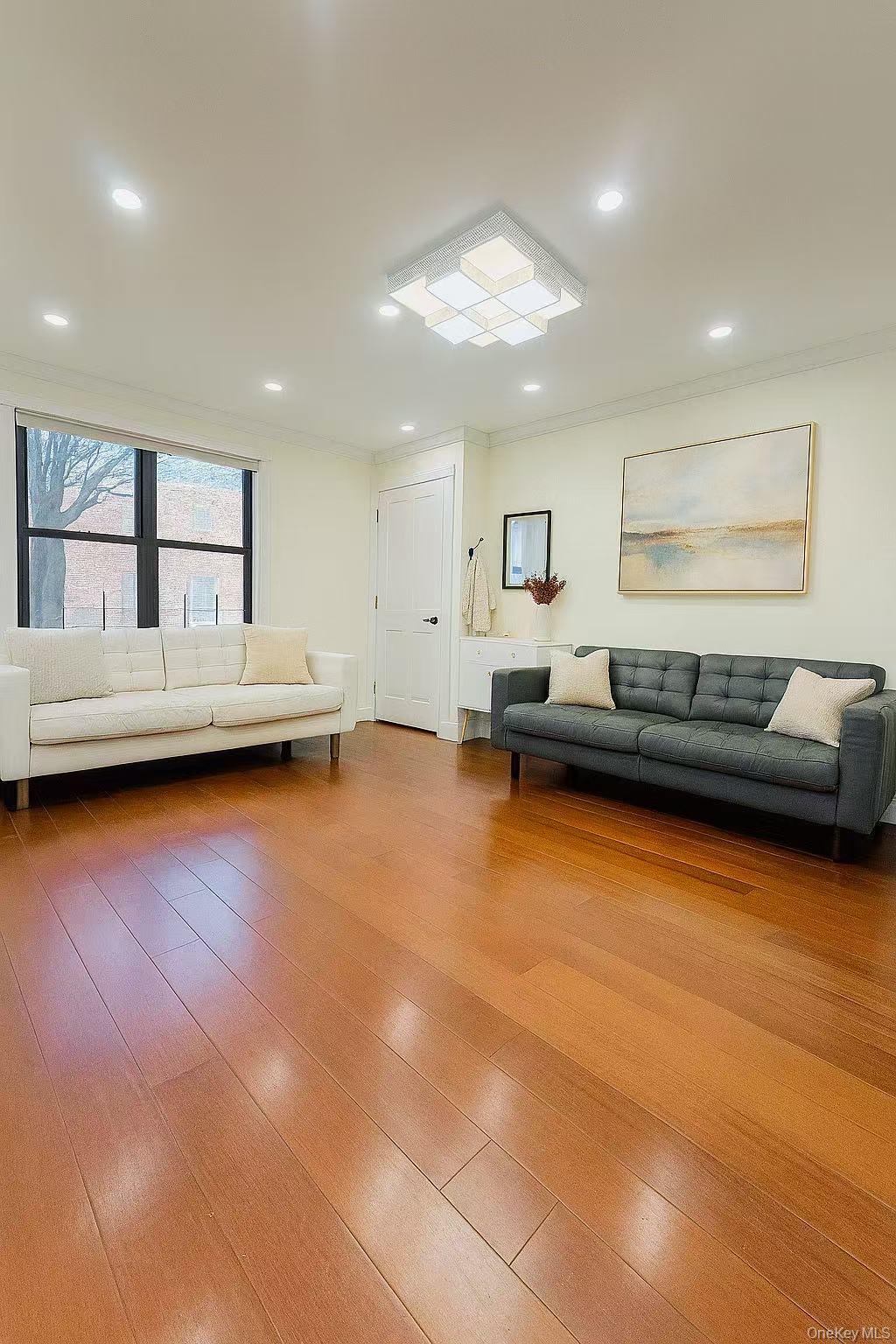 196-36 67th Avenue, Unit 1 Queens, NY 11365 - Photo 3 of 10 a living room with furniture and a wooden floor