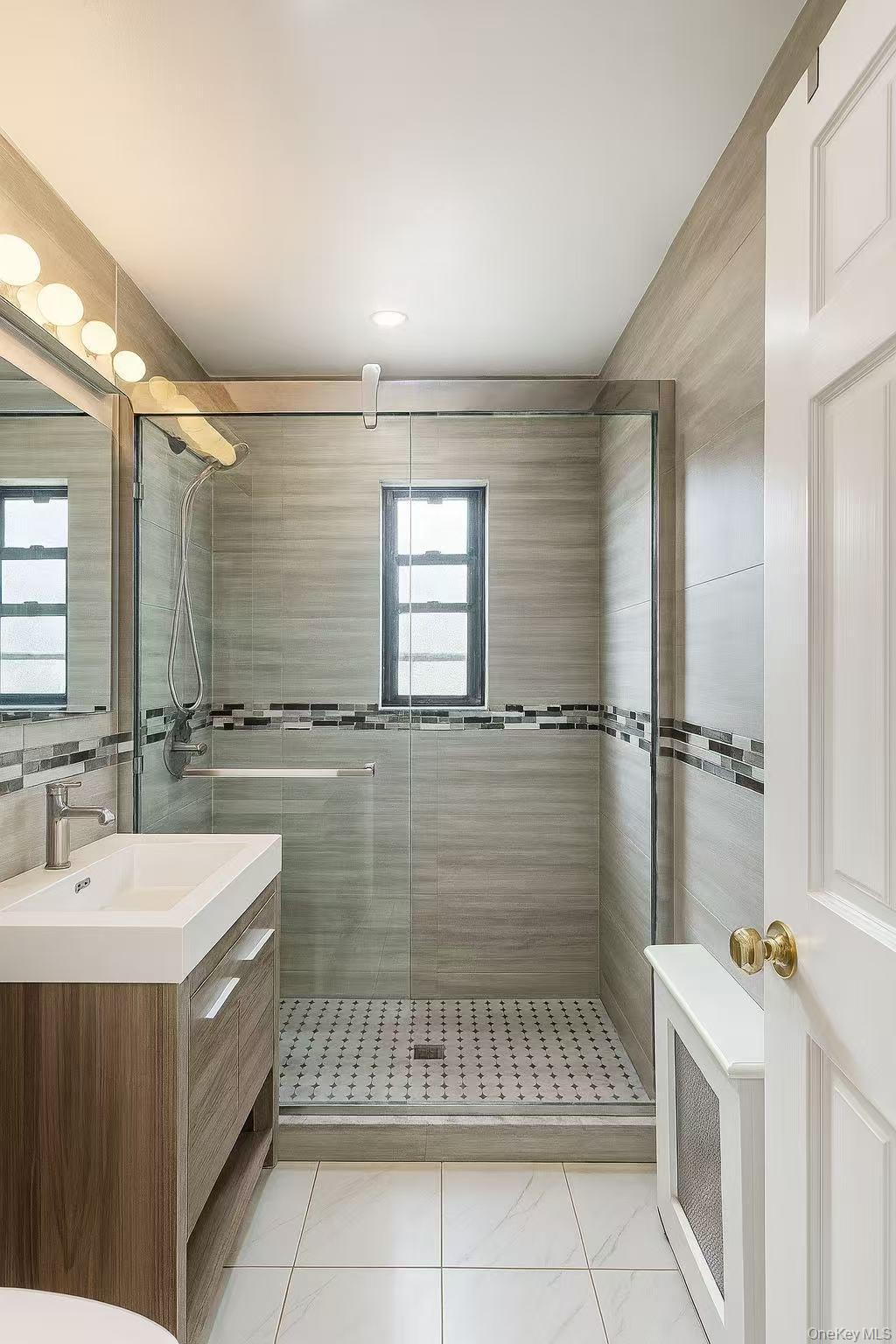 196-36 67th Avenue, Unit 1 Queens, NY 11365 - Photo 8 of 10 a bathroom with a sink a mirror and a bathtub