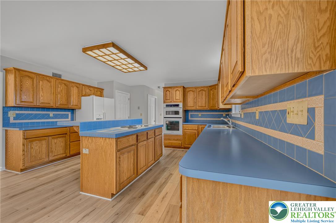 630 Clearfield Road Nazareth, PA 18064 - Photo 31 of 100 Oak cabinetry and tile countertops define this traditional kitchen with a central prep island.