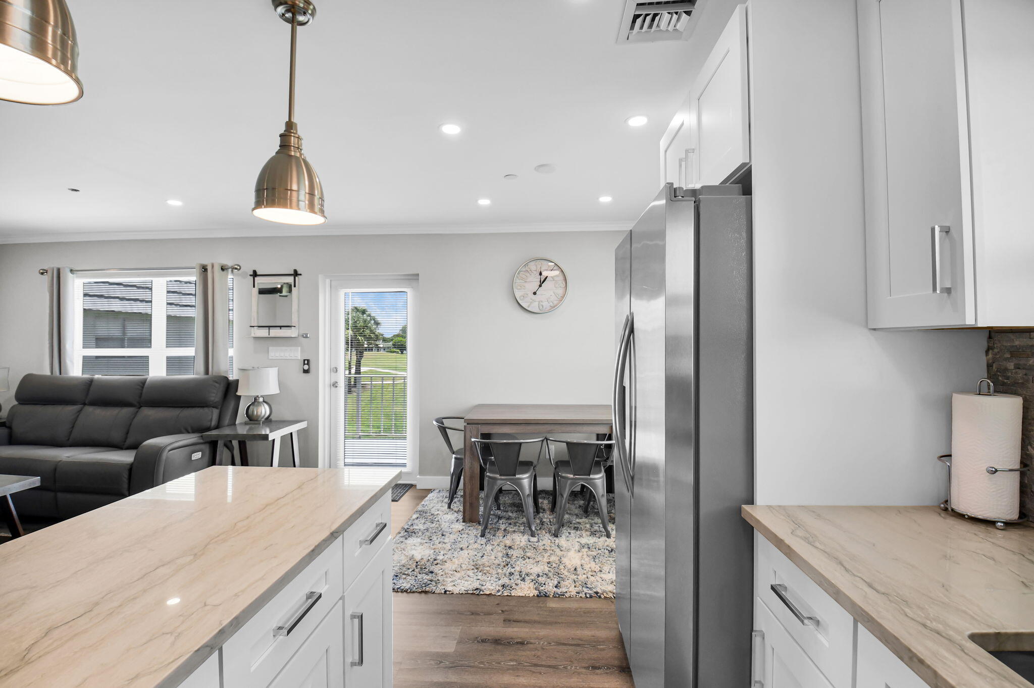 388 Tuscany Lane, Unit 388 Delray Beach, FL 33446 - Photo 15 of 89 a kitchen with stainless steel appliances granite countertop a refrigerator a sink dishwasher a dining table and chairs with wooden floor