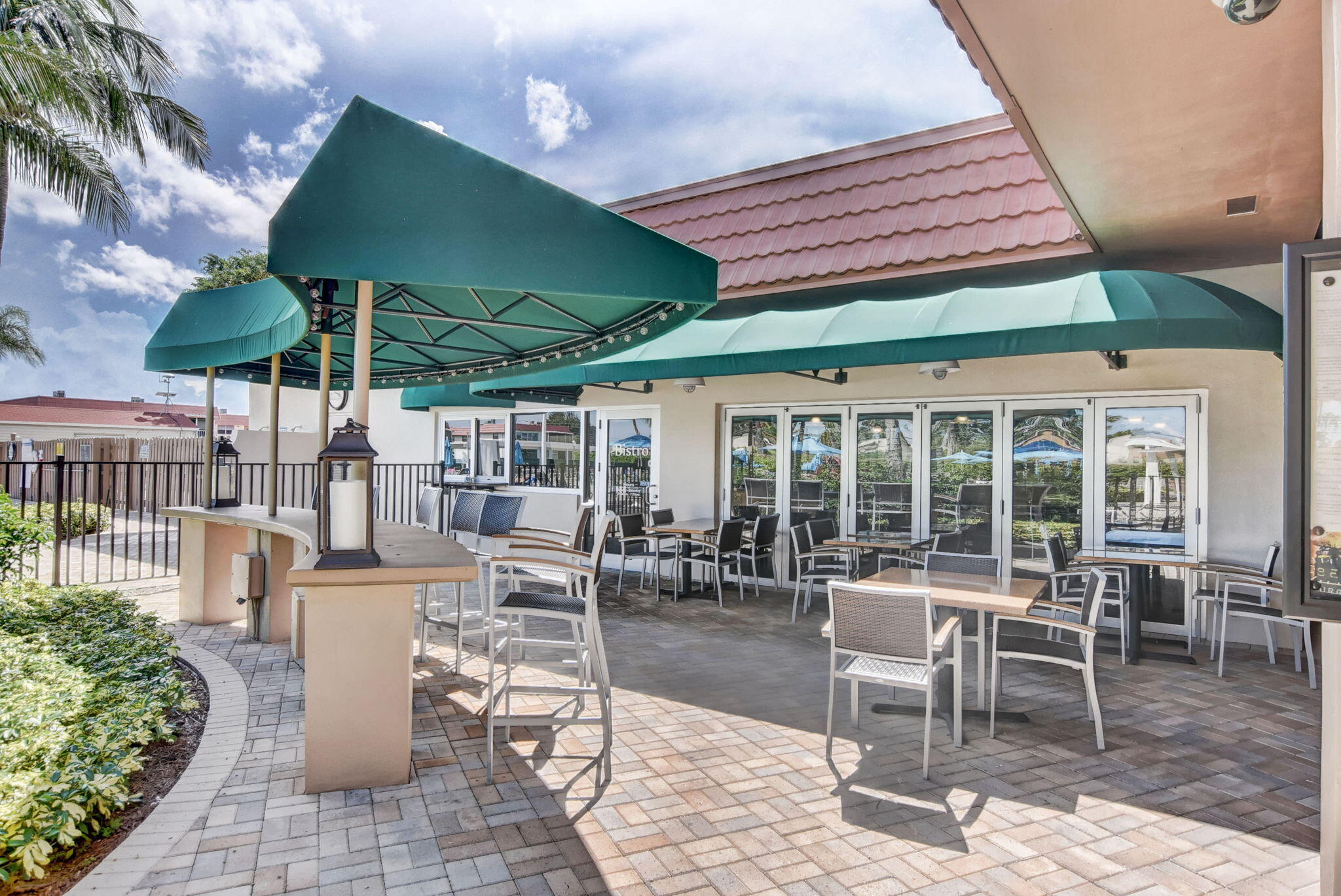 388 Tuscany Lane, Unit 388 Delray Beach, FL 33446 - Photo 66 of 89 a view of a patio with table and chairs under an umbrella