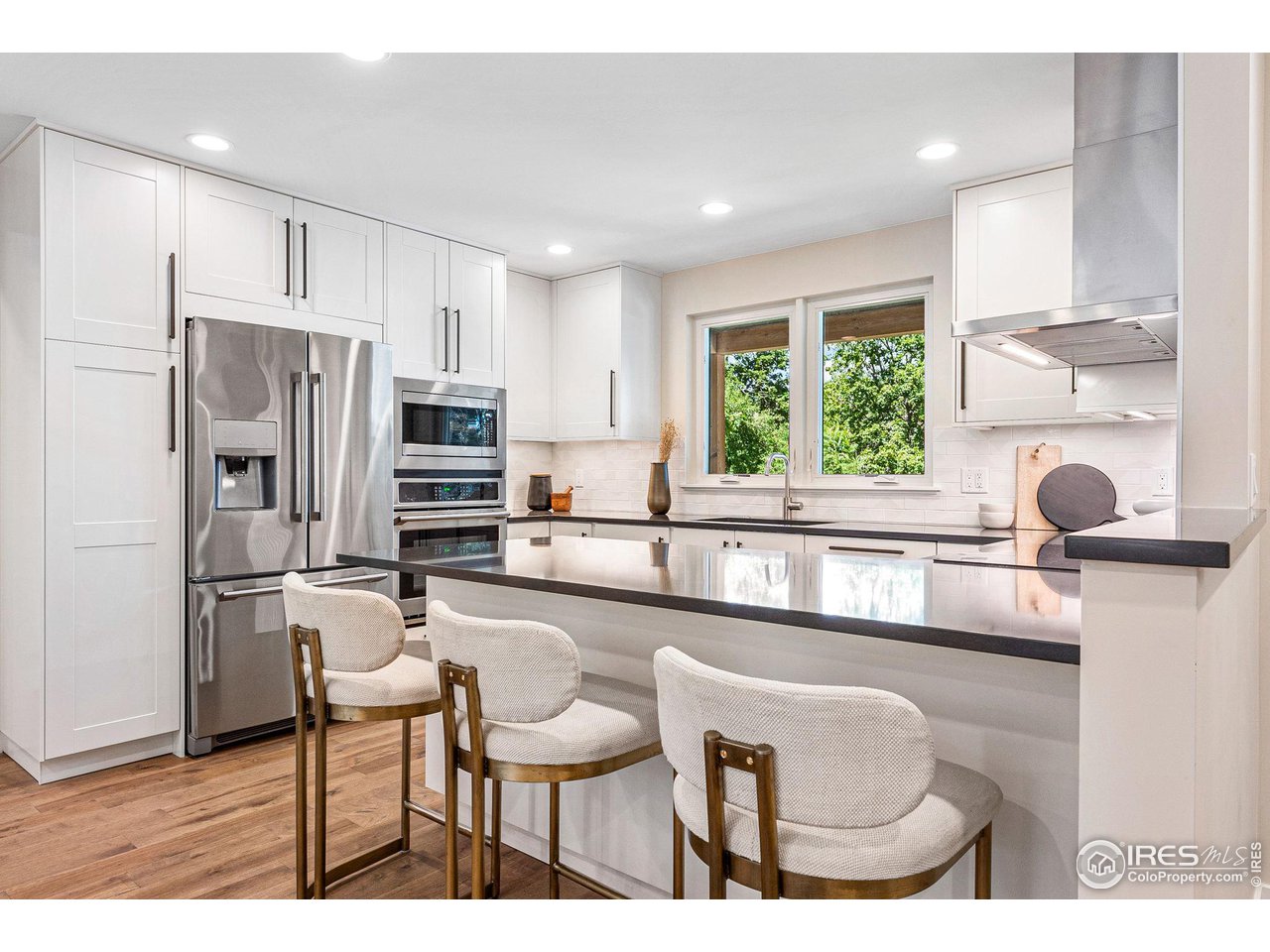 1616 North Street Boulder, CO 80304 - Photo 6 of 32 a kitchen with kitchen island a large window appliances and white cabinets