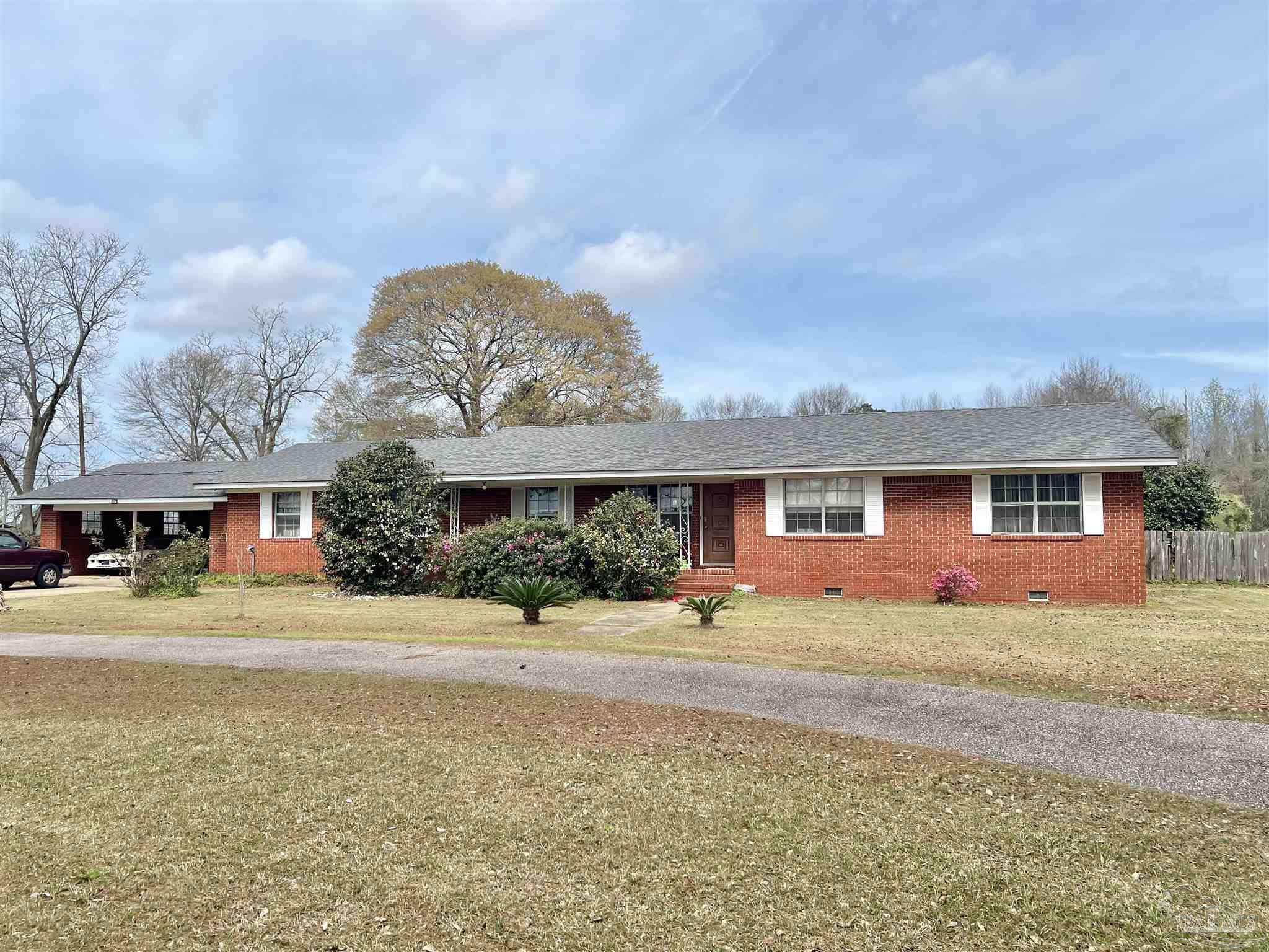 887 Old Bratt Road Atmore, AL 36502 - Photo 1 of 41 a front view of a house with a yard and garage