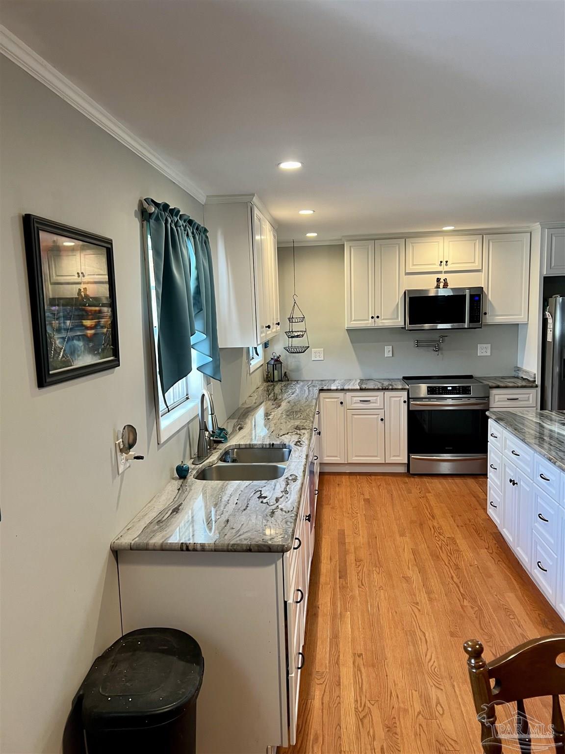 887 Old Bratt Road Atmore, AL 36502 - Photo 3 of 41 a kitchen with a stove a sink and a microwave