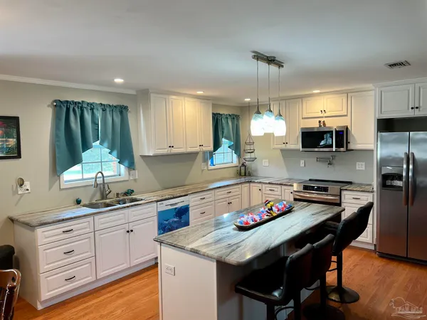 a kitchen with a center island appliances and cabinets