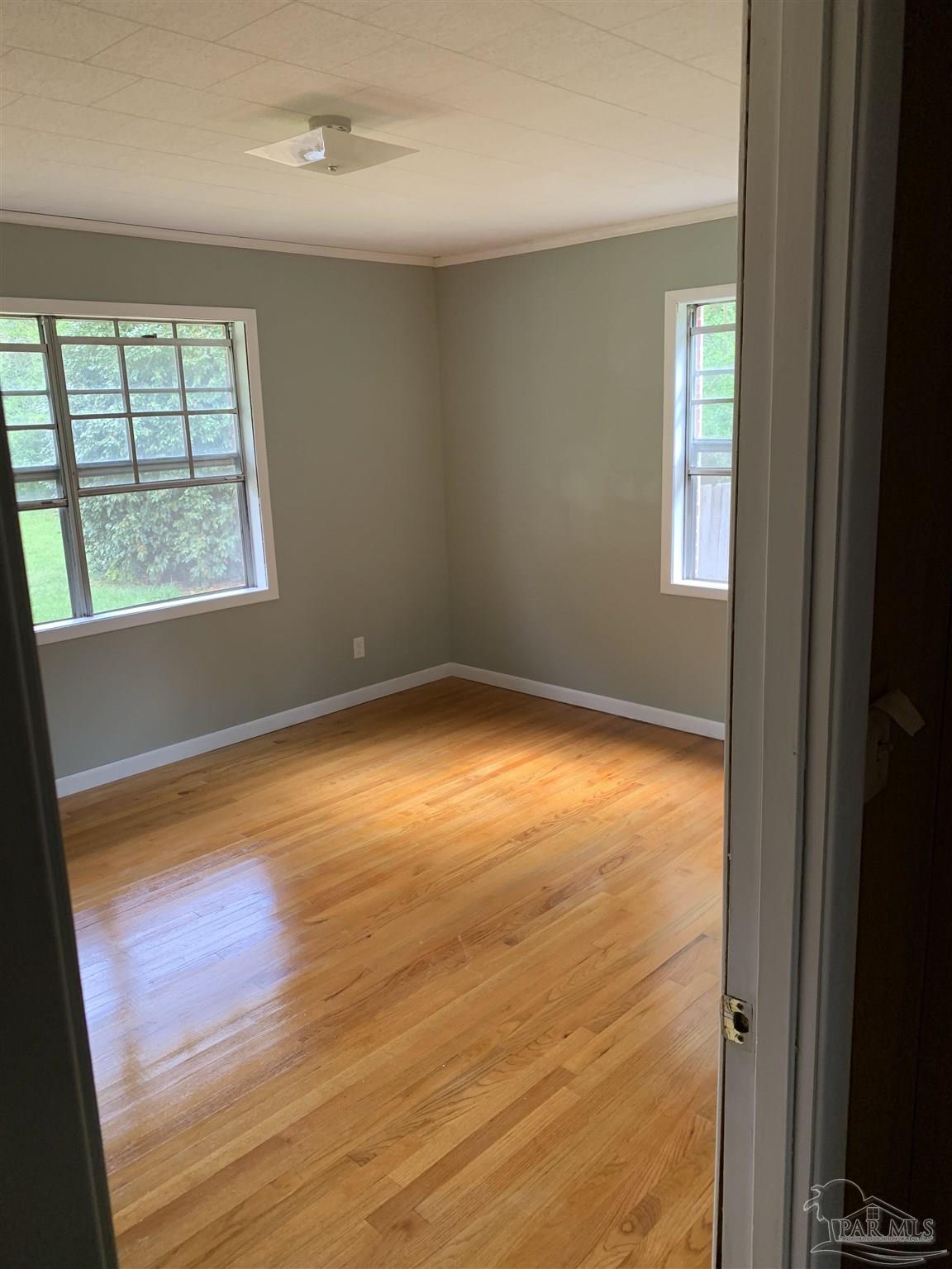 887 Old Bratt Road Atmore, AL 36502 - Photo 10 of 41 a view of an empty room with wooden floor and a window