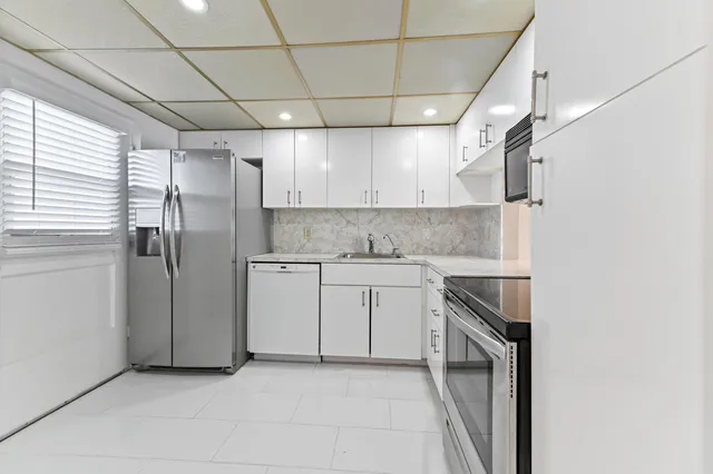 a kitchen with stainless steel appliances a refrigerator sink and microwave