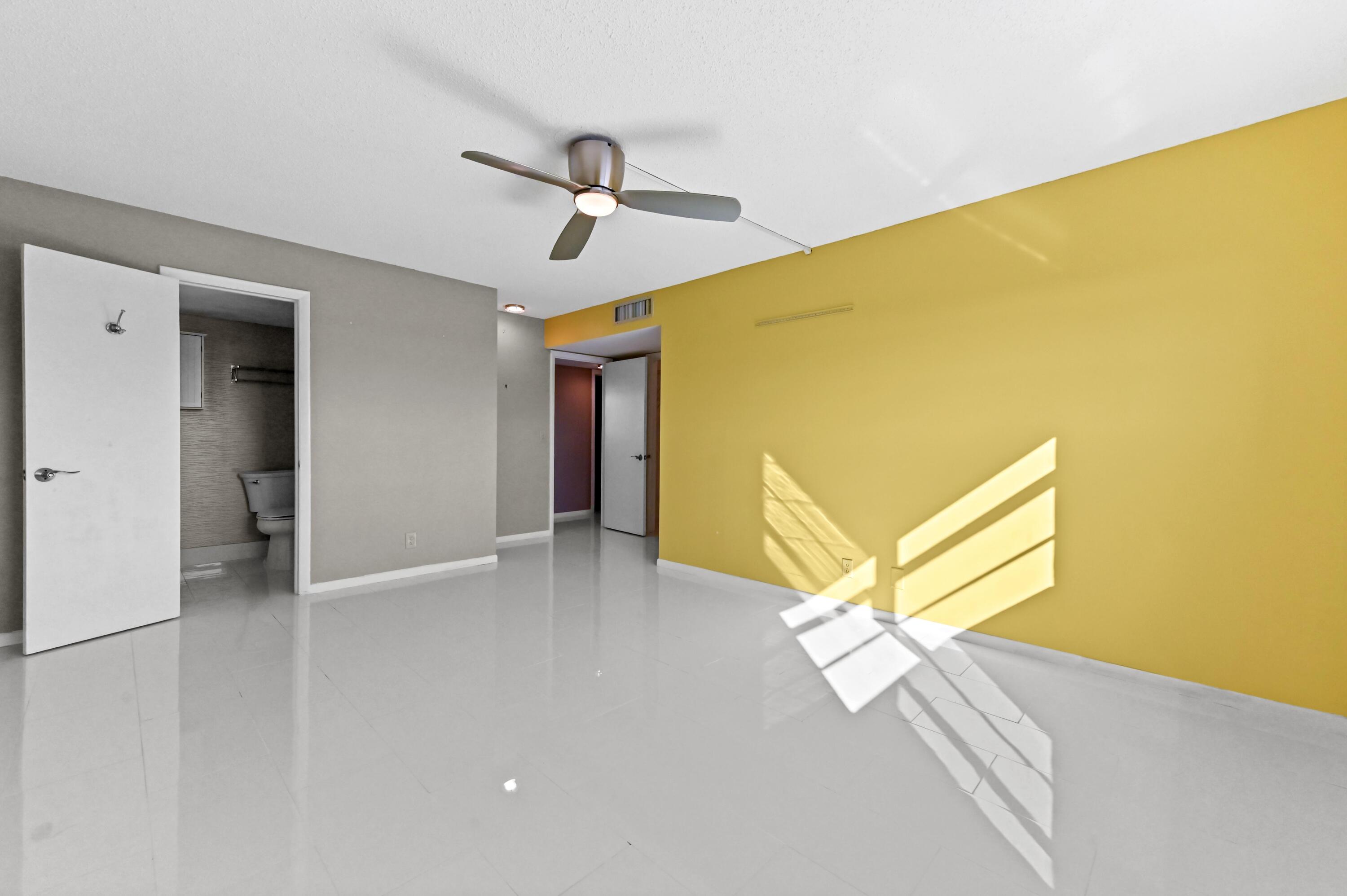 5700 Northwest 2nd Avenue, Unit 503 Boca Raton, FL 33487 - Photo 16 of 40 a view of an empty room with wooden floor and a ceiling fan