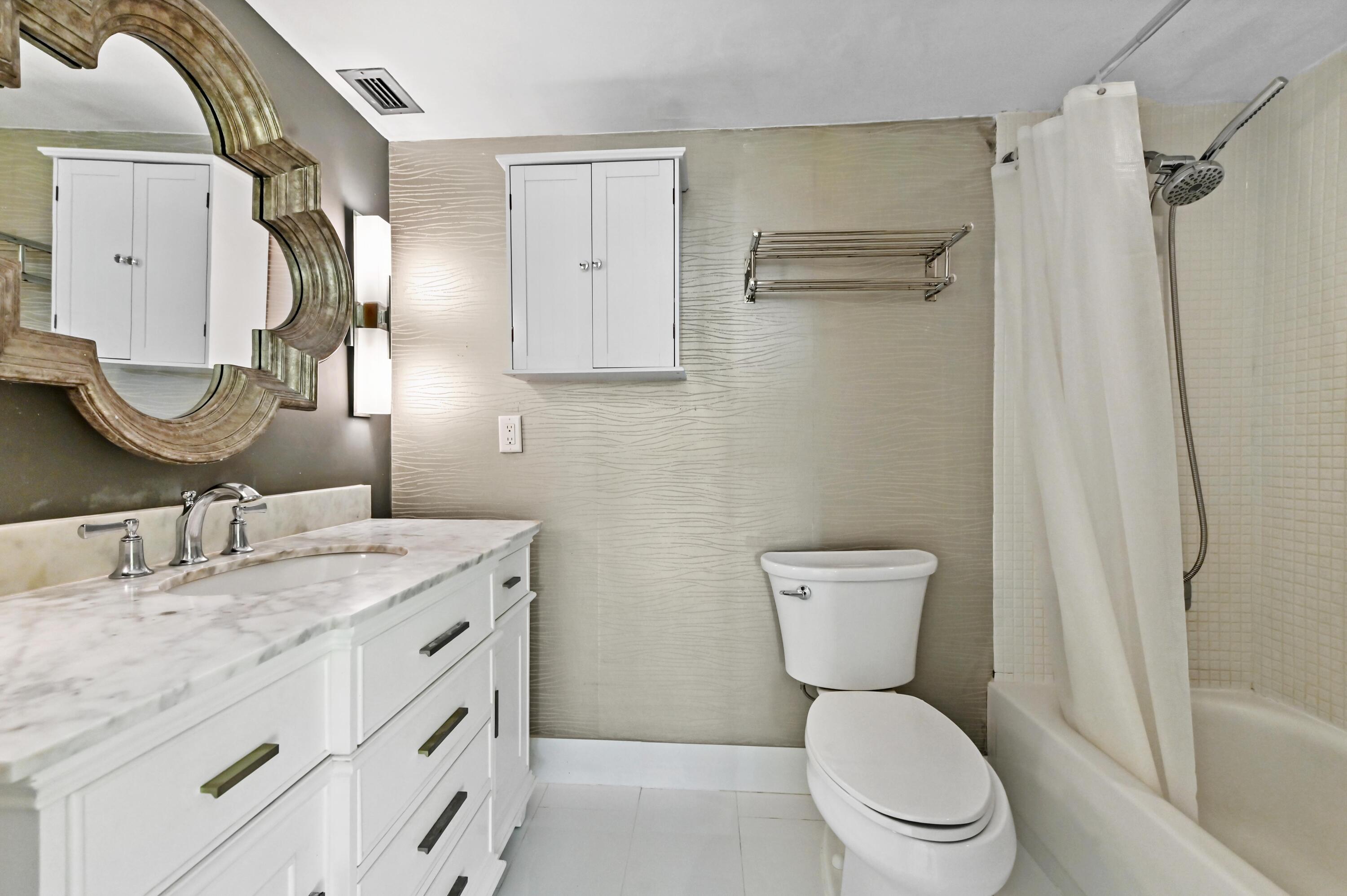 5700 Northwest 2nd Avenue, Unit 503 Boca Raton, FL 33487 - Photo 18 of 40 a bathroom with a granite countertop toilet sink and mirror