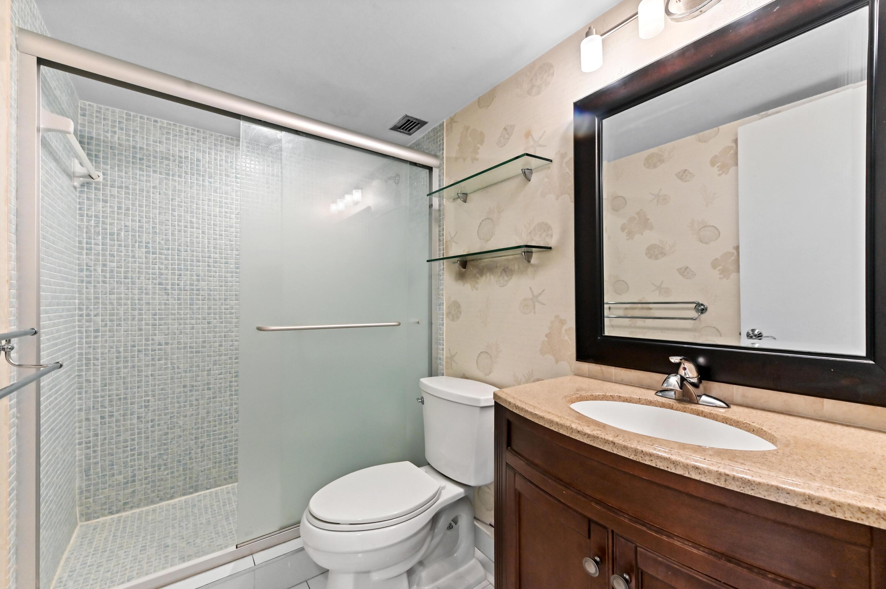 5700 Northwest 2nd Avenue, Unit 503 Boca Raton, FL 33487 - Photo 25 of 40 a bathroom with a granite countertop sink toilet and shower