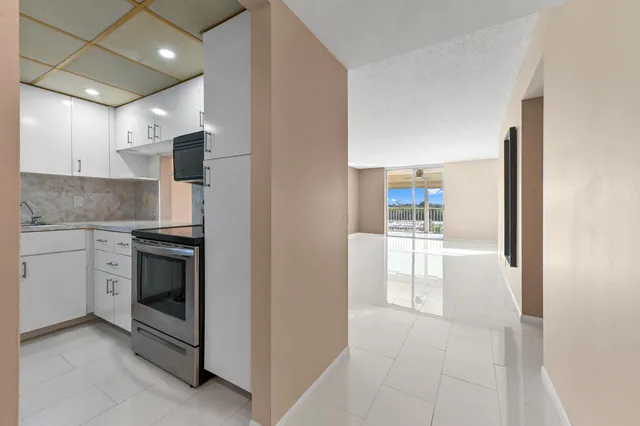 a kitchen with stainless steel appliances granite countertop a refrigerator a stove and a sink