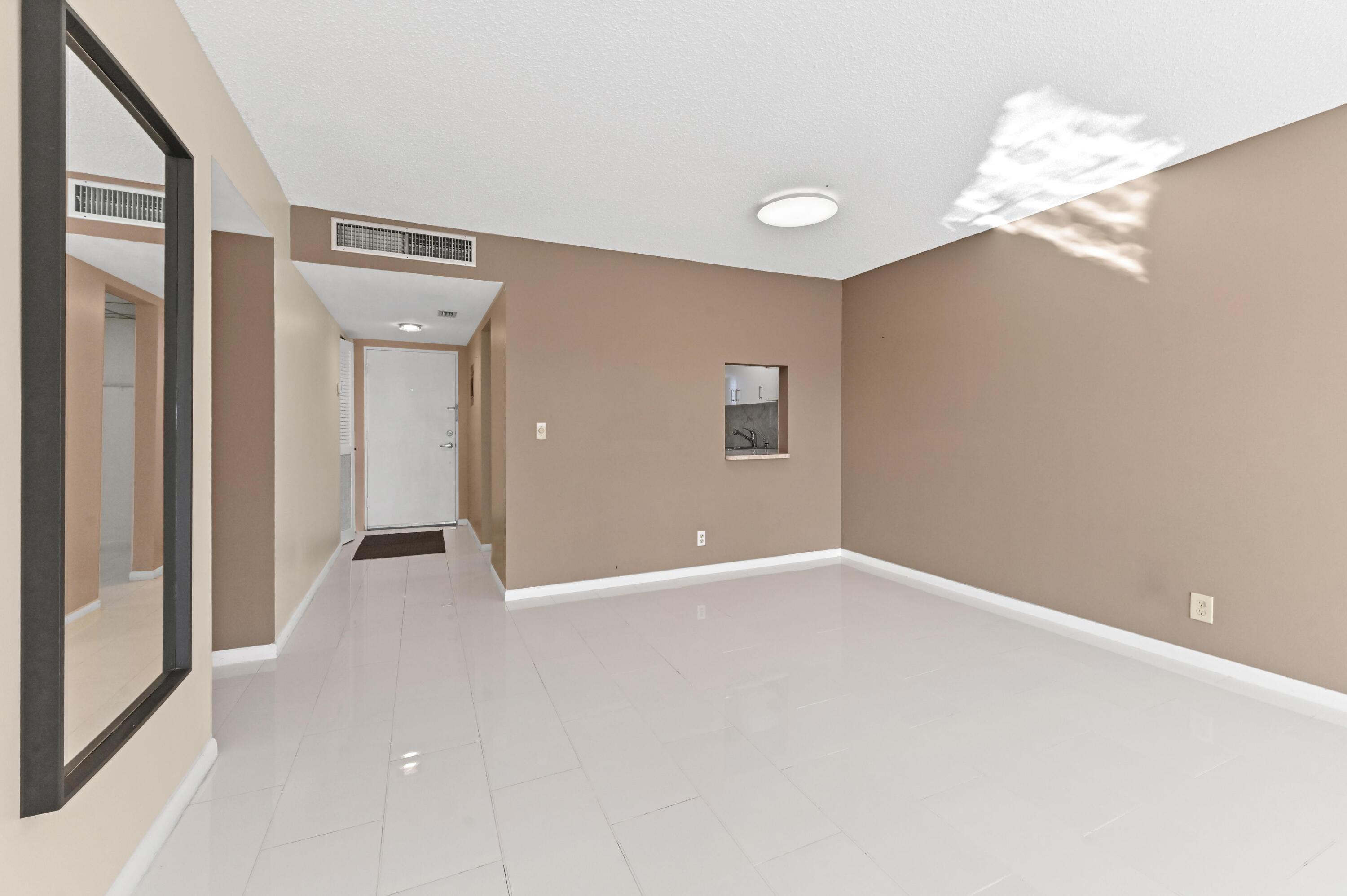 5700 Northwest 2nd Avenue, Unit 503 Boca Raton, FL 33487 - Photo 6 of 40 an empty room with chandelier fan and windows